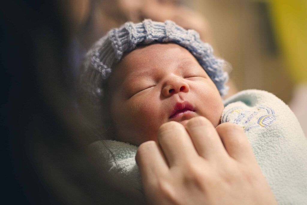 Little baby sleeping in his or her mother's arms (article by mom after baby)