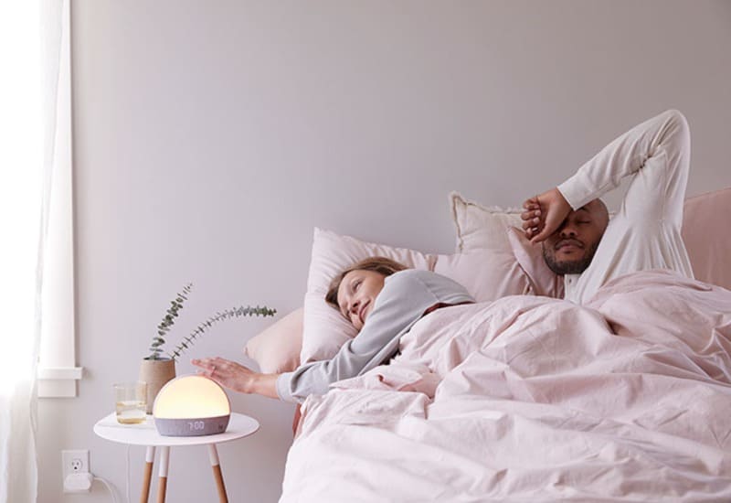 bright and airy image of a couple waking up next to the Hatch Restore