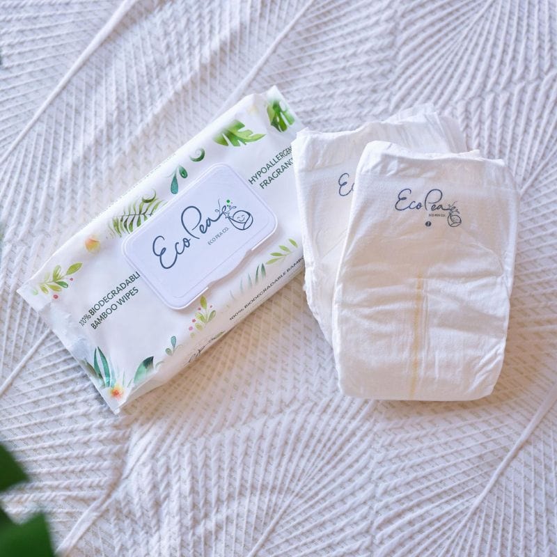 flatlay lifestyle image of the Eco Pea. Co diapers and wipes on a white blanket