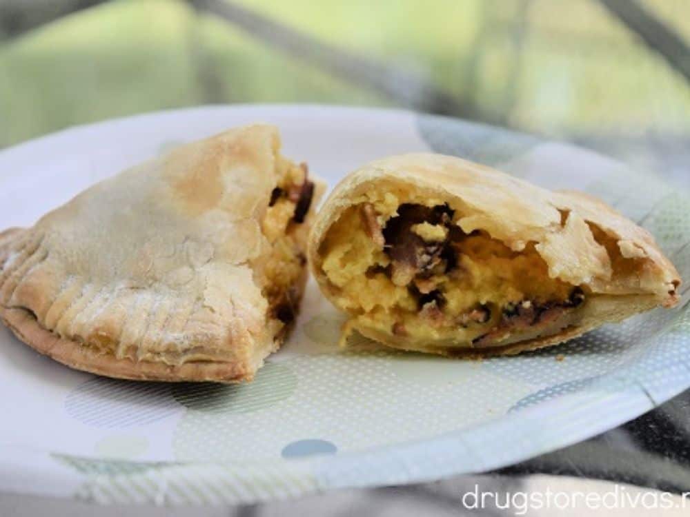 image shows a breakfast empanada stuffed with eggs, cheese, and sausage.