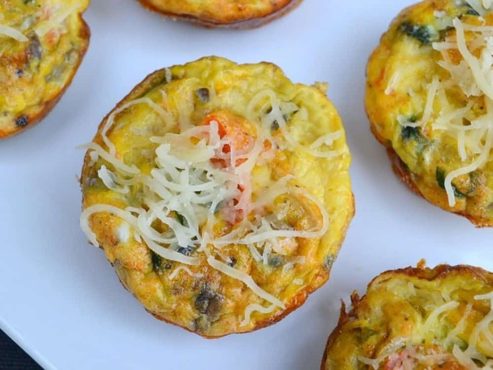 image is a flatlay shot of baked egg muffins with white cheese sprinkled on top.