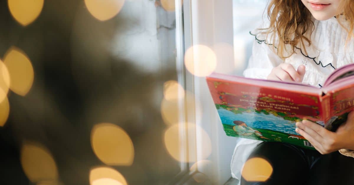 close up image of a little girl holding a christmas book in her hands