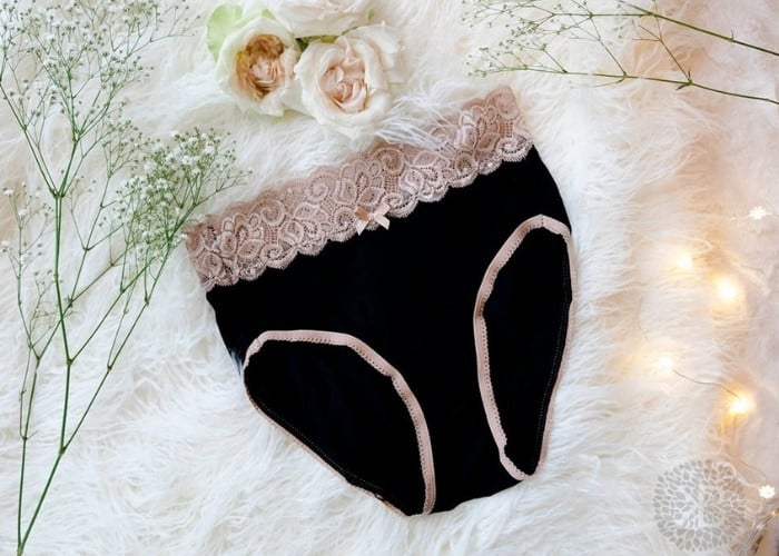 flat-lay shot of black kindred bravely high waisted postpartum panties with floral accents around the scene