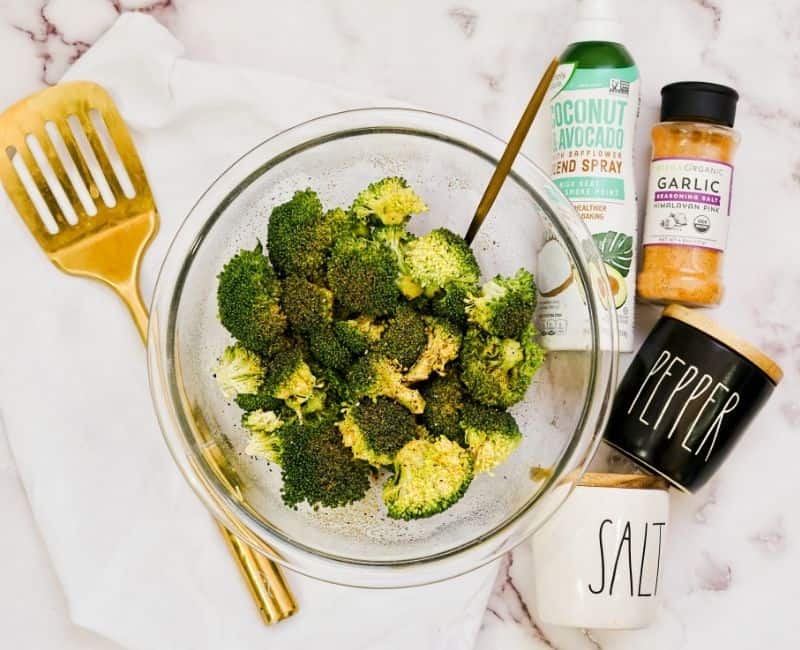 Flatlay shot of Air Fryer Garlic Parmesan Broccoli next to gold spatula and spices 