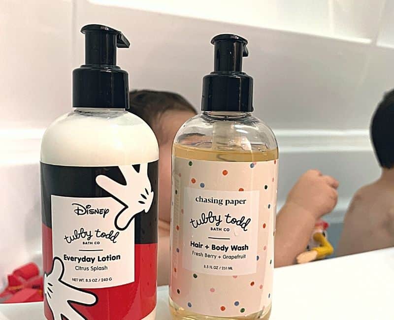 Background of photo is bathtub during child bathtime with focused image on 2 Tubby Todd Products.