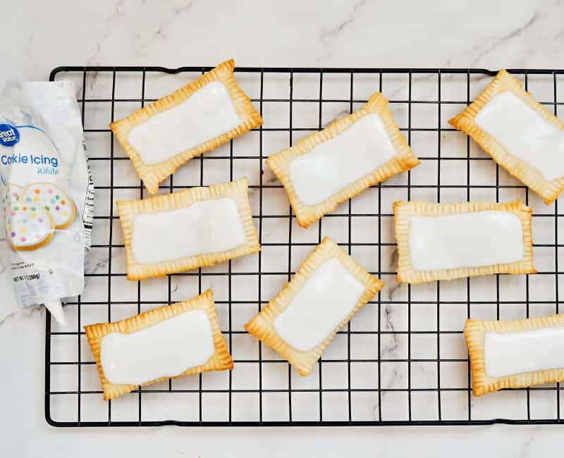 air fryer pop tarts on drying rack with icing on top of the pop tarts