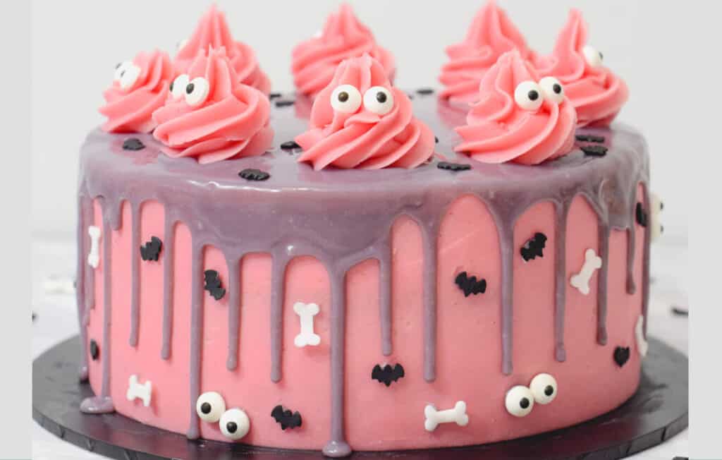 Pink halloween cake on a black serving dish