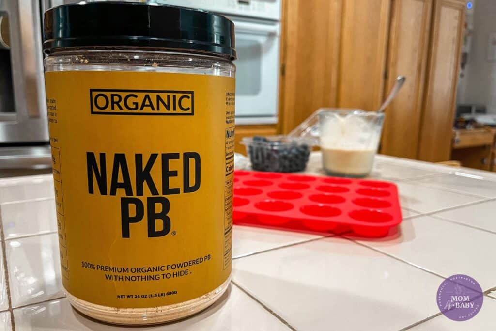 Image features a close up shot of Naked Nutrition's Organic Powdered Peanut Butter in a kitchen