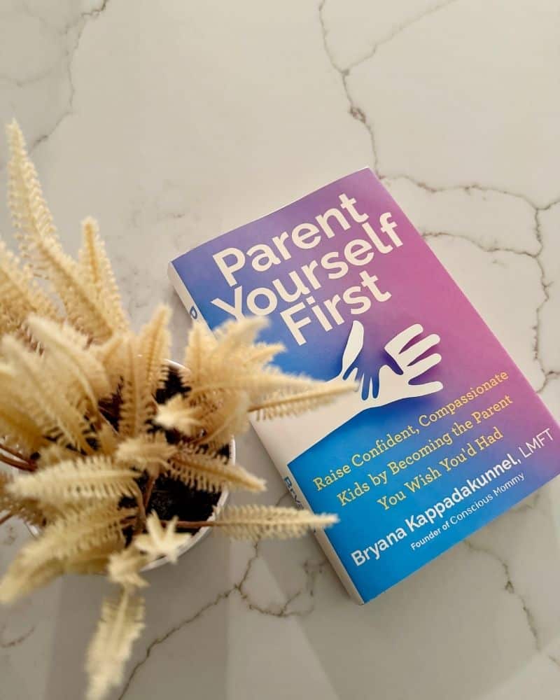 flatlay image of Parent Yourself First book next to a tan faux plant