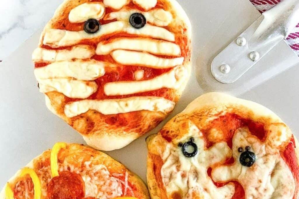 This image shows 3 mini pizzas with a variety of halloween themed mini pizzas 