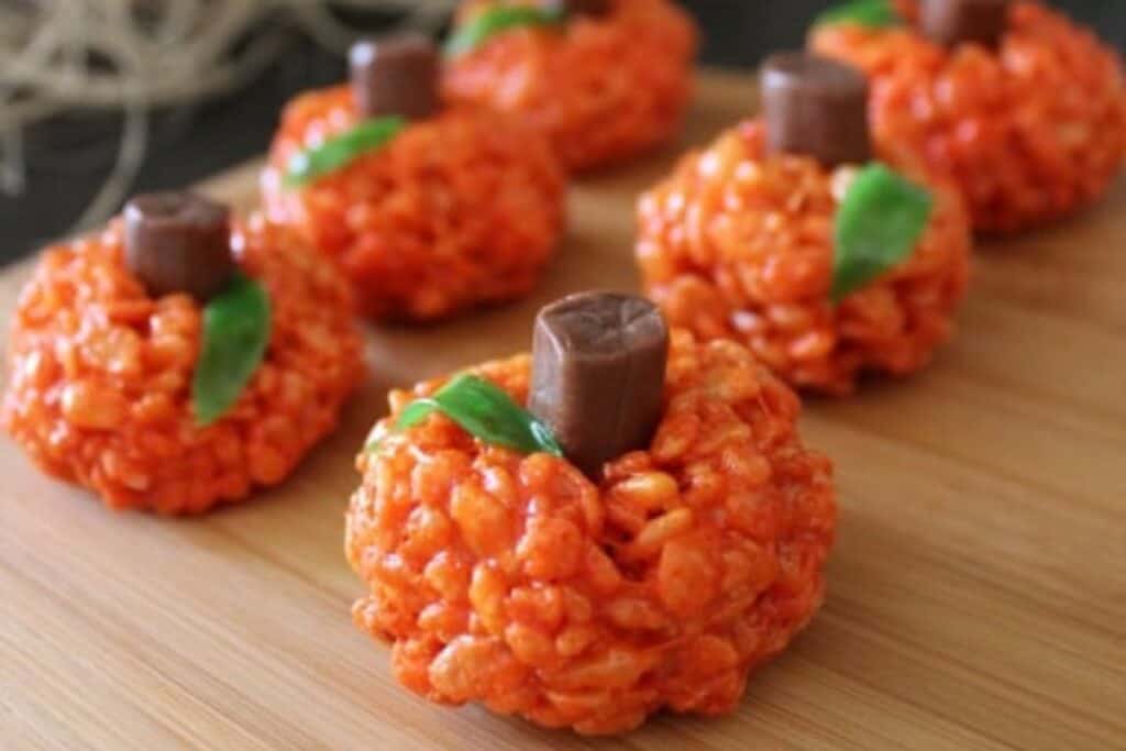 This image shows an adorable recipe made out of rice krispies to look like orange pumpkins 