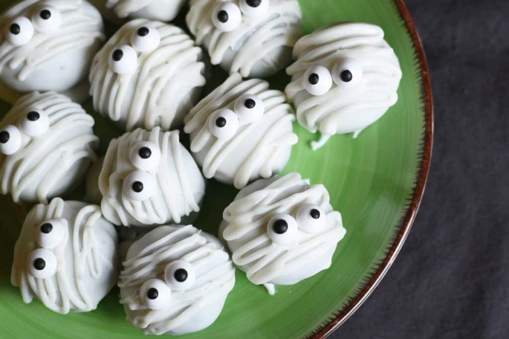 this image shows oreo balls in white frosting with candy eyes — a perfect spooky treat for halloween