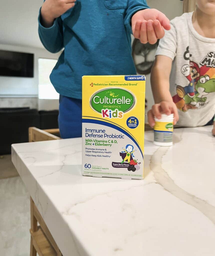 Close up image of Culturelle Kids Probiotics with 2 kids standing in the background