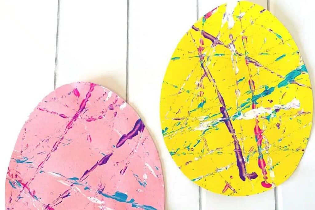 Image of a flat lay pink (on left) and yellow (on right) easter egg craft from 'Simply Full of Delight'