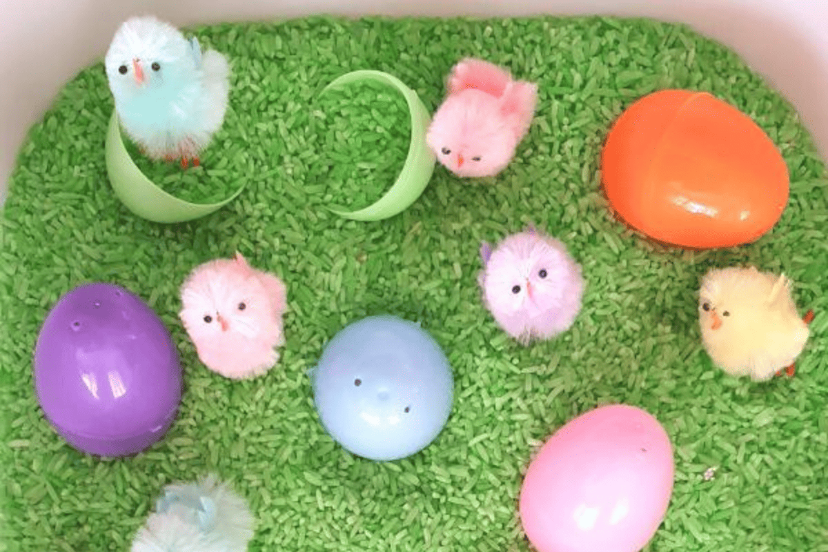 flat lay close up image of green rice topped with easter eggs and easter craft items