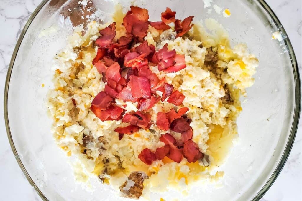 image shows bacon being folded into the mashed potatoes