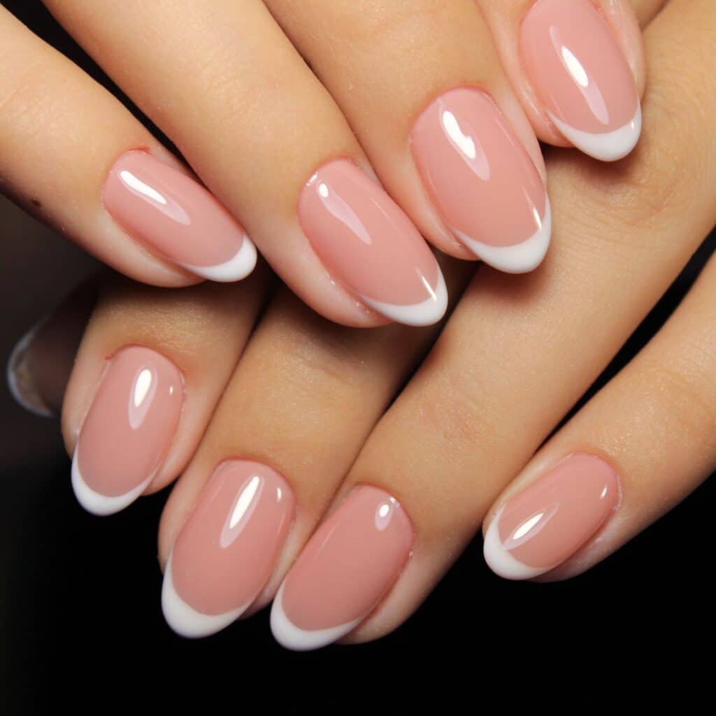 close up image of a basic french tip manicure on almond/round shaped nails.