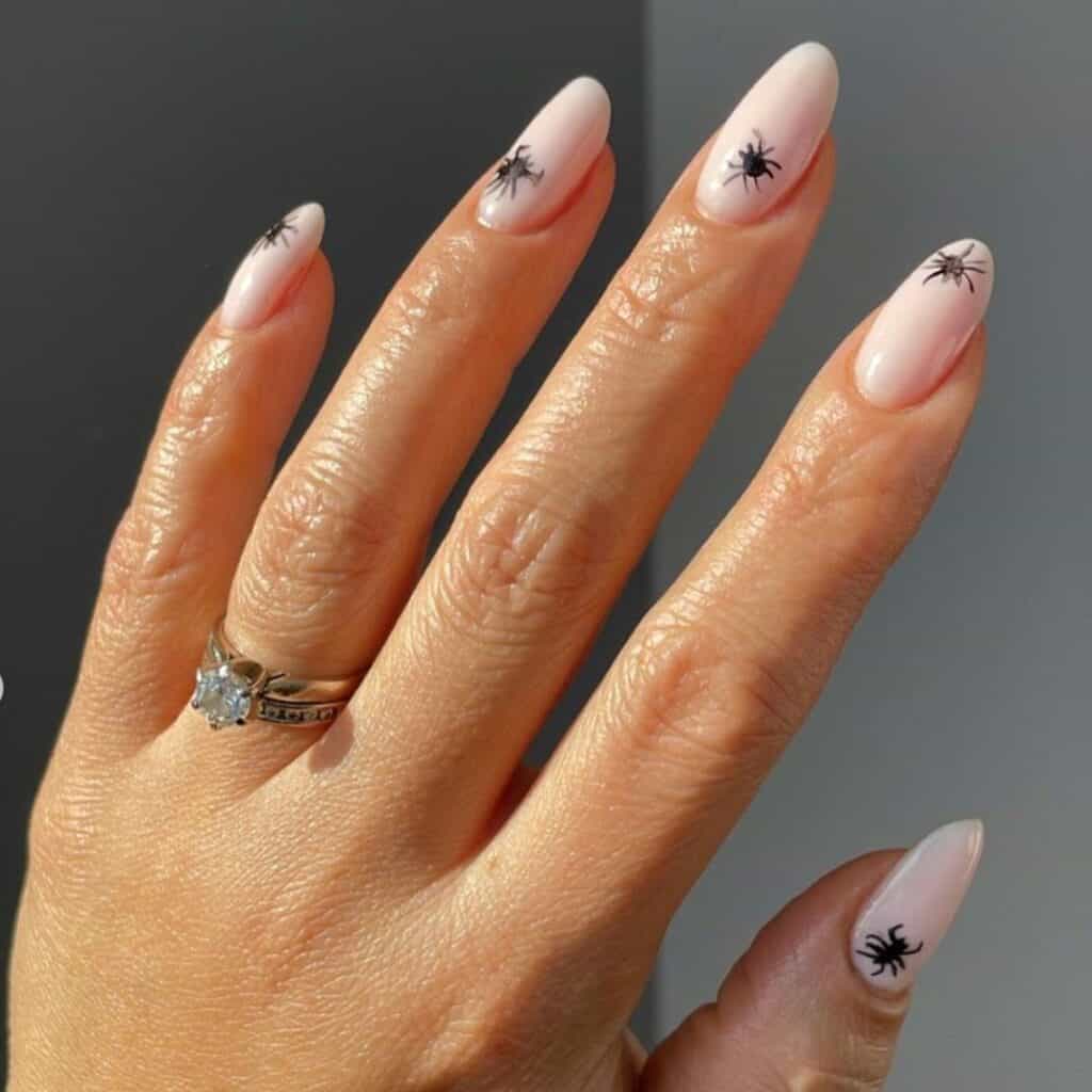 simple natural nail design with a small black spider on them by @myminimalistmani on instagram