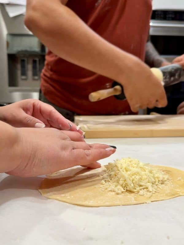 pasteles ball rolled out and being filled with cheese