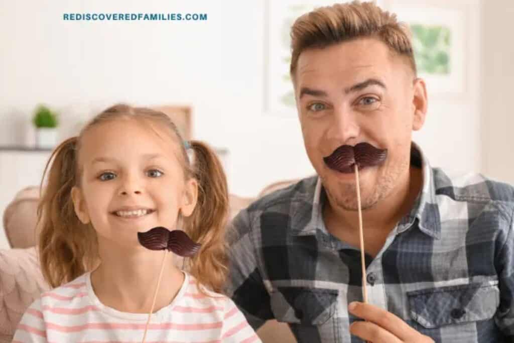 close up of daughter and dad holding chocolate mustaches