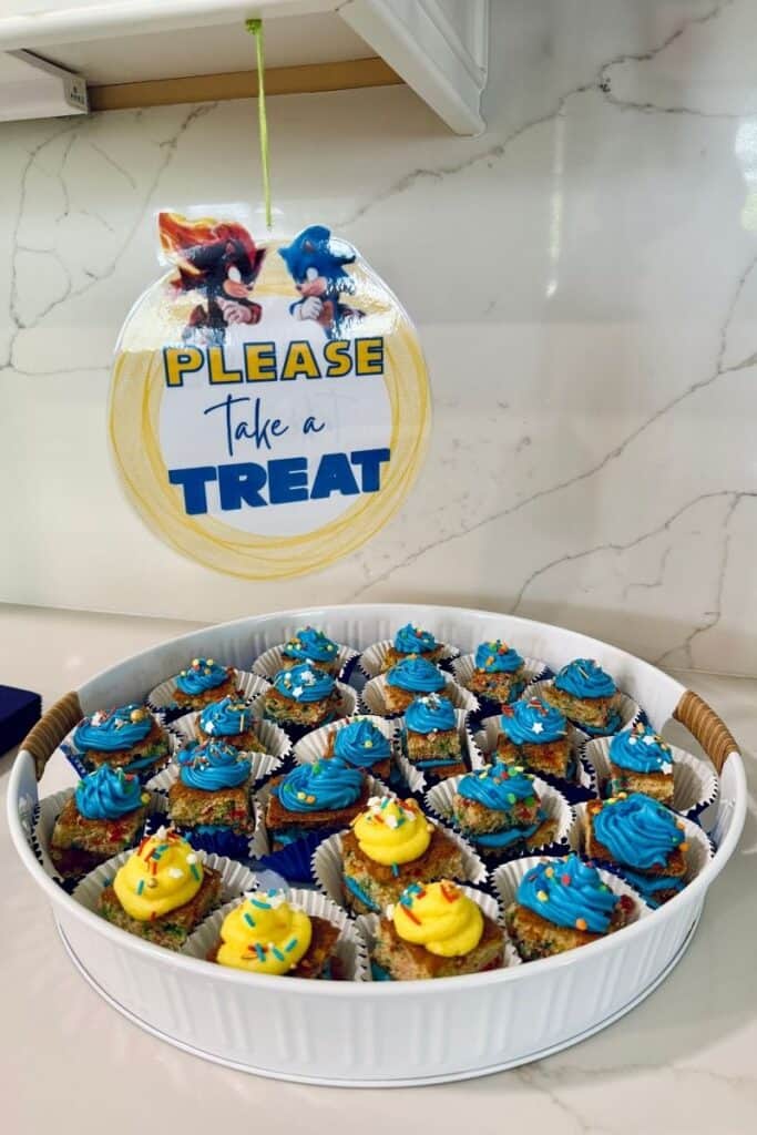Sonic birthday dessert table mini cakes topped with blue and yellow frosting and sprinkles