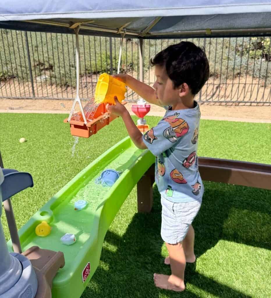 close up of a young child playing with water in the Step 2 water table