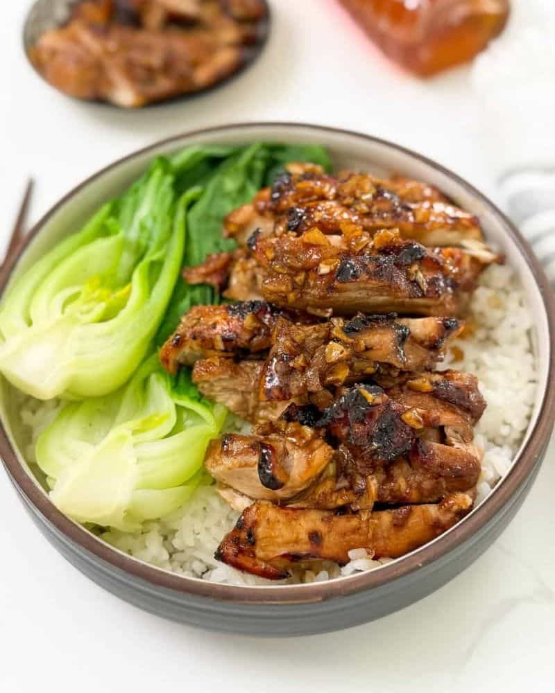 Honey Butter Chicken Thighs on rice a plate next to Cabbage