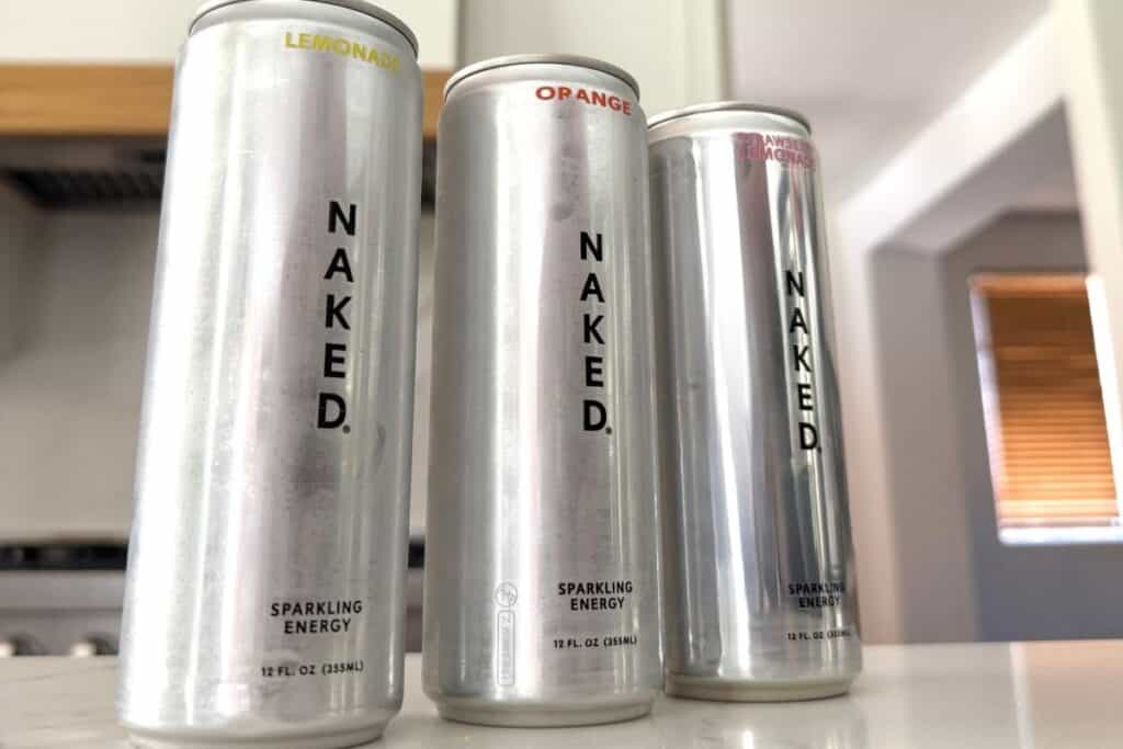 Naked nutrition energy drink cans side by side on a kitchen counter