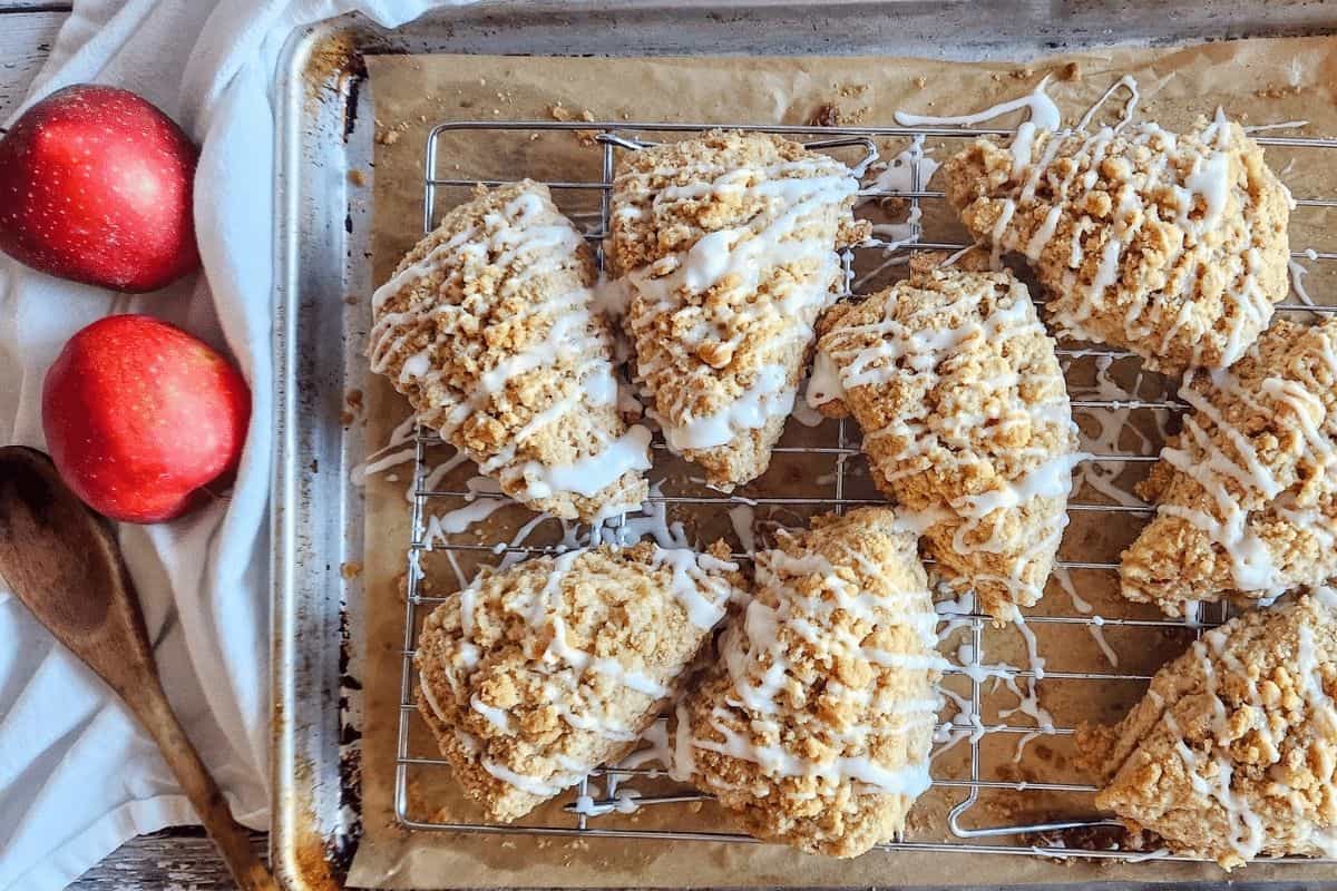 apple crumble scones in a baking dish next to some red apples