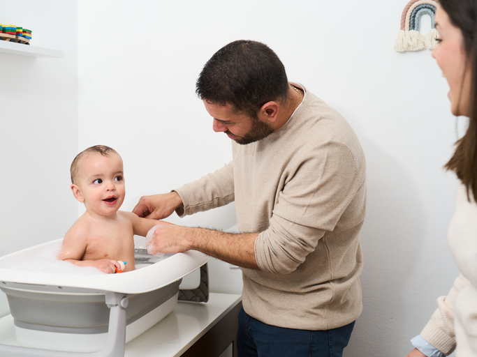 Husband helping with baby in newborn stages